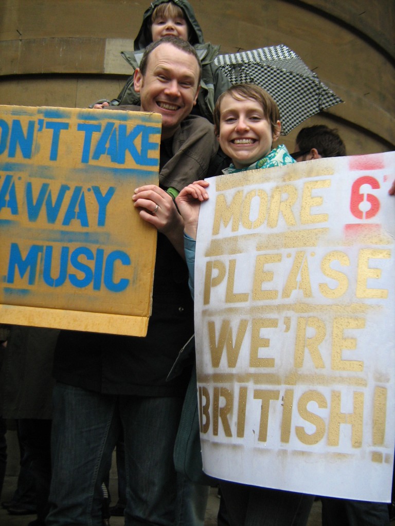 Nicky, Euan and Ollie Taylor at 6music protest - more six please we're british Nicky, Euan and Ollie Taylor. Nicky says: It's a really fantastic station, we have it in all day, first thing in the morning the radio goes on. We love it. Euan: there's such a variety It's the only place to go for new music. We like Mumford and Sons don't we Ollie? I don't know where we'd find new music otherwise. The DJs are fantastic, they're so knowledgeable. Euan was in Tokyo at one point and he sent a text in to Nemone's show knowing I'd be listening and she read it out and I was at home and I was like 'oh it's for me!'.