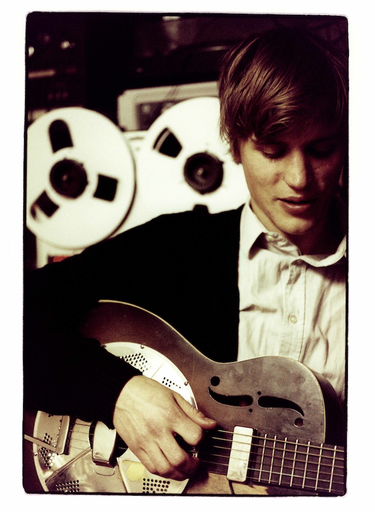 Johnny Flynn, playing the guitar in a studio