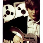 Johnny Flynn, playing the guitar in a studio